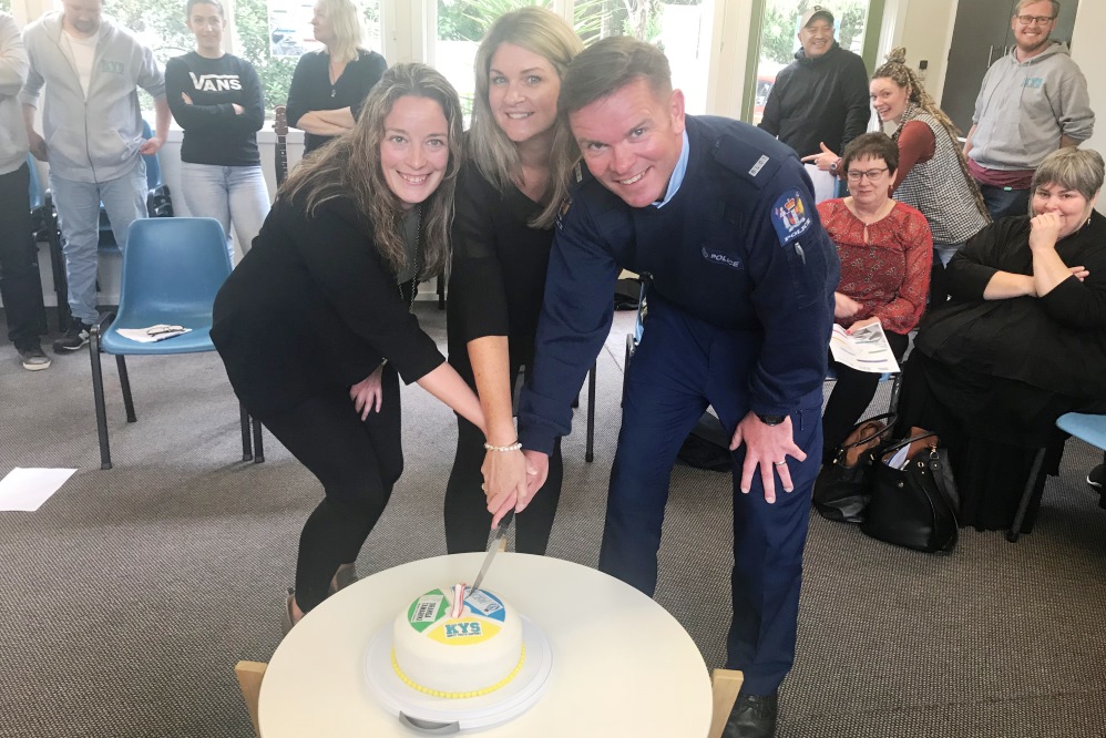 Representatives from the three organisations cutting the cake